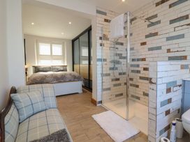 A bathroom with a shower and a bed at Lenny's Place in Watchet