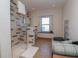 A bathroom with shower and towel holder at Lenny's Place in Watchet