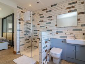 A bathroom with a shower, toilet, and sink at Lenny's Place Watchet