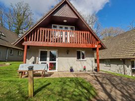A house with a balcony and garden at Mayfly Lodge in St Tudy