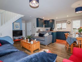 A living room with a kitchen and dining area at Mayfly Lodge St Tudy