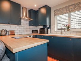 A kitchen with cabinets and appliances at Mayfly Lodge in St Tudy
