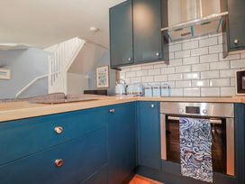 A kitchen with cabinets and an oven at Mayfly Lodge in St Tudy