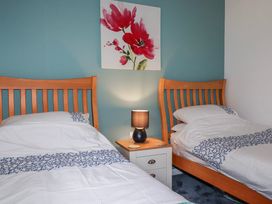 A bedroom with two beds and a lamp at Mayfly Lodge in St Tudy