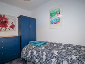 A bedroom with a bed and wardrobe at Mayfly Lodge in St Tudy