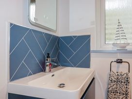 A bathroom with a sink faucet and a window at Mayfly Lodge in St Tudy