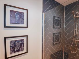 A bathroom with framed art of sea creatures at Mayfly Lodge St Tudy