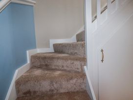 A stairway with carpet and a handrail at Mayfly Lodge in St Tudy
