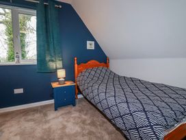 A bedroom with a bed and bedside table at Mayfly Lodge in St Tudy