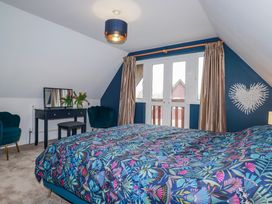 A bedroom with a bed and a table with flowers at Mayfly Lodge in St Tudy