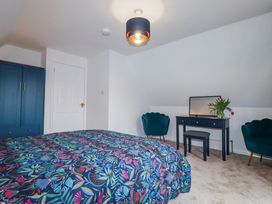 A bedroom with a bed and wardrobe at Mayfly Lodge in St Tudy