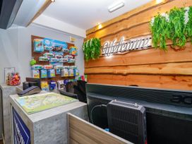 A reception area with a counter and display rack at Mayfly Lodge in St Tudy