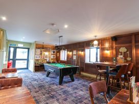 A games room with a pool table and seating areas at Mayfly Lodge in St Tudy