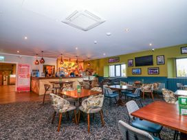 A bar area with tables and chairs at Mayfly Lodge in St Tudy