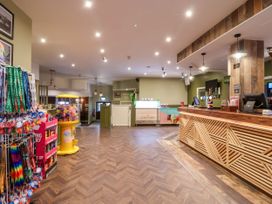 A lobby with a reception desk and merchandise display at Mayfly Lodge St Tudy