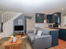 A living room with a sofa and television at Mayfly Lodge in St Tudy
