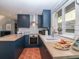 A kitchen with cabinets and a countertop at Mayfly Lodge in St Tudy