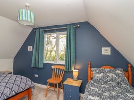 A bedroom with two beds and a window at Mayfly Lodge in St Tudy