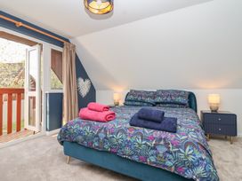 A bedroom with a bed and bedside table at Mayfly Lodge in St Tudy
