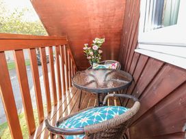 A balcony with a table and two chairs at Mayfly Lodge St Tudy