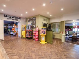 A recreation area with arcade machines and a gumball machine at Mayfly Lodge St Tudy