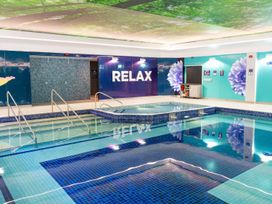 A swimming pool with a relax sign at Mayfly Lodge in St Tudy