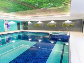 An indoor pool with a jacuzzi at Mayfly Lodge St Tudy