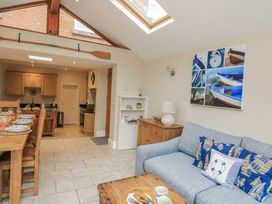 A living room with a sofa and dining area at Shipwrights in Salcombe