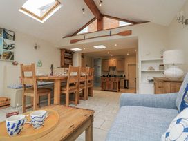 A kitchen with a dining area and sofa at Shipwrights in Salcombe