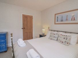 A bedroom featuring a bed, pillows, and a lamp at Shipwrights in Salcombe