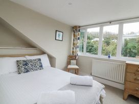A bedroom with a bed and window at Shipwrights in Salcombe