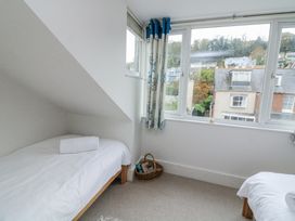 A bedroom with beds and a window at Shipwrights in Salcombe