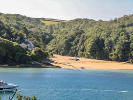 A beach with a house and trees at Shipwrights in Salcombe