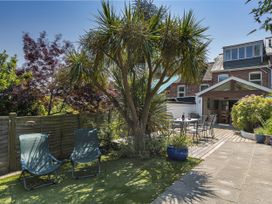 A garden with palm tree and seating area at Shipwrights in Salcombe