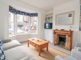 A living room with a fireplace and a coffee table at Shipwrights Coronation Road in Salcombe