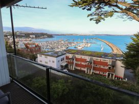 A view of a marina with boats and coastline at 20 Heath Court in Brixham