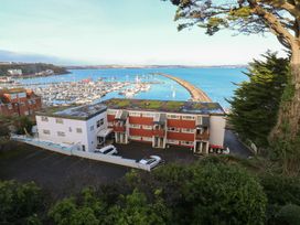 A view of a marina with buildings and cars at 20 Heath Court in Brixham