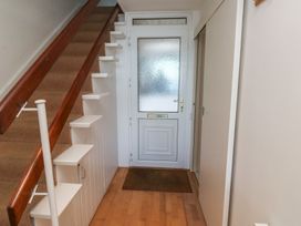 A hallway with stairs and a front door at 20 Heath Court in Brixham
