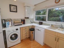 A kitchen with appliances including a washing machine and a dishwasher at 20 Heath Court Brixham