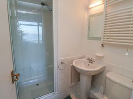 A bathroom with a shower, toilet, and sink at 20 Heath Court in Brixham