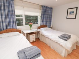 A bedroom with two beds and a desk at 20 Heath Court in Brixham