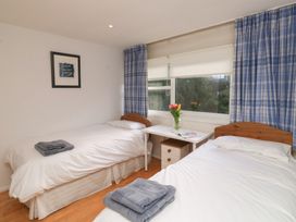 A bedroom with two beds and a table at 20 Heath Court in Brixham