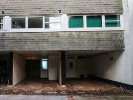 An outdoor area with parking spaces and doors at 20 Heath Court in Brixham