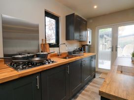 A kitchen with a stove, sink, cabinets, and a door at Cabin