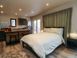 A bedroom with a bed and kitchen area in a Cabin