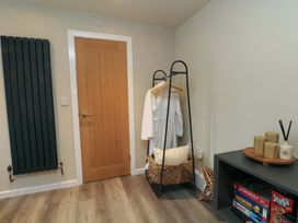 A corner of a room with a coat rack and games on a shelf at Cabin