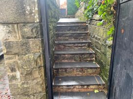 A staircase leading up with stone walls and gate at The Cabin in Loveclough near Crawshawbooth