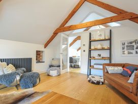 A living room with a sofa and shelving unit at The Dairy in 
