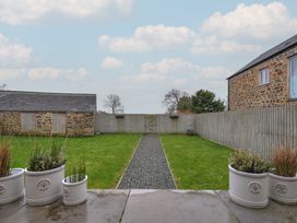 A garden with a gravel path and planters at The Dairy in 