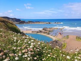 A beach scene with people and flowers at The Dairy in Bridgerule